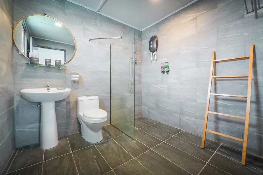 A contemporary bathroom with large-format grey stone tiles at Shun Shun Water Bungalows